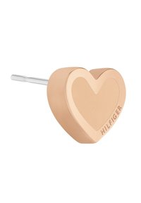 Pendentif en forme de cœur en or rose avec une finition lisse et mate et une épingle d'attache couleur argent ; marque visible sur le côté.