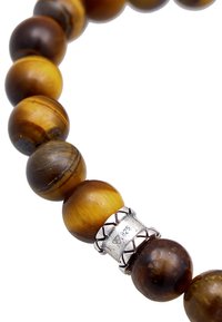 En pärlarmband med runda tigeröga-pärlor i nyanser av brunt och guld, med en silveravskiljare märkt "925". Slät textur, glansig finish.