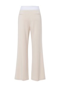 Beige wijde broek met een witte elastieke tailleband, voorzien van twee achterzakken en een gladde textuur. Uitlopende stijl van de knie naar beneden.