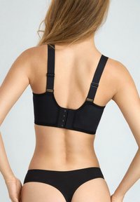 Czarna bielizna z szerokim pasem, regulowanymi ramiączkami i zapięciem na haftki. Materiał wydaje się gładki, prezentując minimalistyczny design.