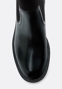 Czarne skórzane botki Chelsea o gładkim wykończeniu, z elastycznymi bocznymi panelami i teksturowaną czarną gumową podeszwą. Okrągły czubek i elegancki design.