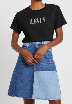 Sort bomulds-T-shirt med sølvfarvet "LEVI'S"-logo, kombineret med en denim A-formet nederdel med kontrasterende lyse og mørkeblå paneler.