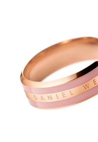 Ruusu-kultainen rannekoru, jossa on sileä, kiiltävä vaaleanpunainen osa ja kaiverrus "DANIEL WELLINGTON" isoilla kirjaimilla.