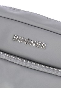 Borsetta in tessuto grigio con logo "BOGNER" in rilievo argentato, superficie testurizzata e chiusura con cerniera.
