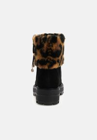 Crne antilop čizme do gležnjeva s leopard uzorkom od umjetnog krzna na rubu i debelim, čvrstim crnim potplatom. Sadrži detalj sa patentnim zatvaračem sa strane.