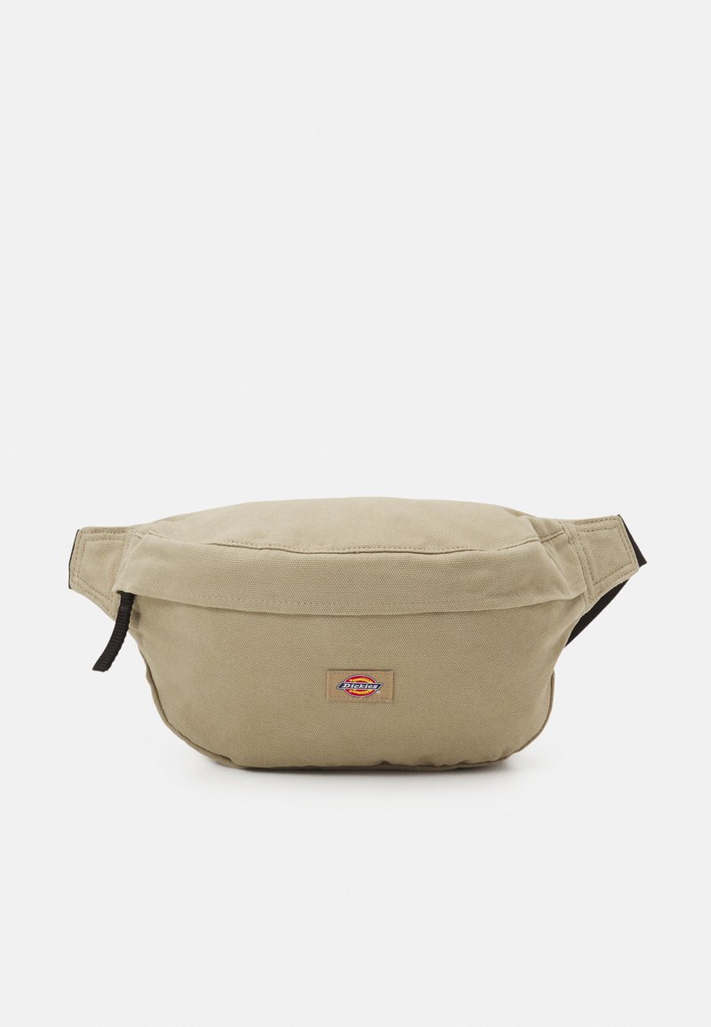 Beige szövet deréktáska cipzáras záródással, állítható pántokkal és logóval ellátott folttal. Lekerekített forma, lágy tapintással.