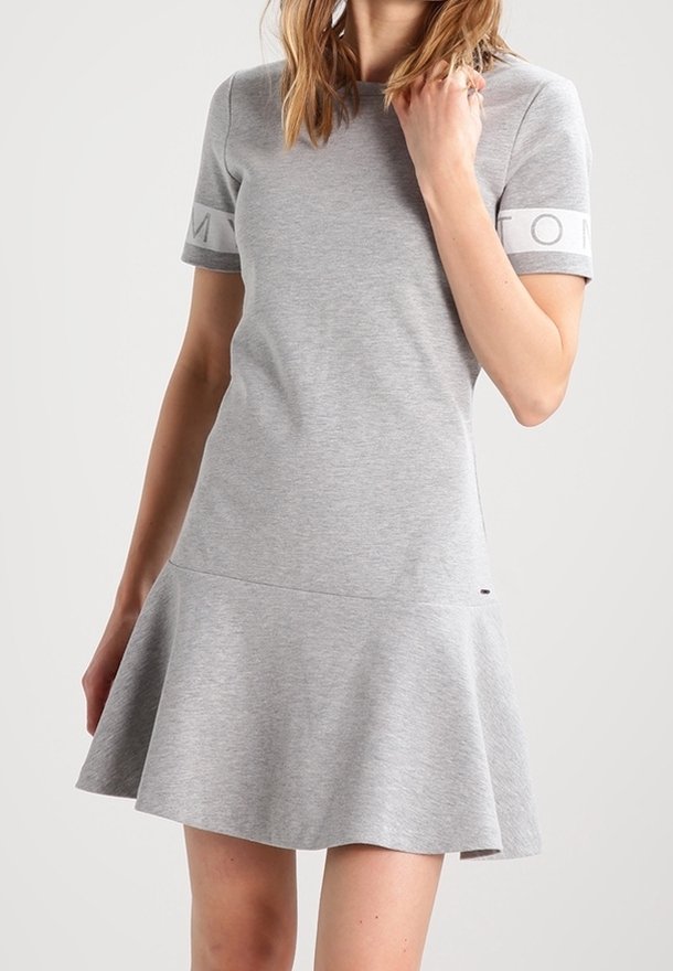 Grå bomullsklänning med en figurnära överdel och utsvängd kjol, med korta ärmar och logotypdetaljer på ärmarna. Slät textur, avslappnad design.