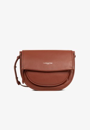 Bruine leren Lancaster Paris schoudertas met gebogen klep en verstelbare riem, voorzien van zilverkleurige studs en logo aan de voorkant.