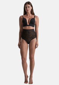 Zwart ondergoedset met een diepe plunge-bh en high-waisted slipjes. De bh heeft een gladde stof; de slipjes zijn doorschijnend met een bloemig kantpatroon.