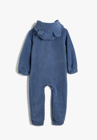 Bodysuit en polaire bleu avec une capuche dotée de deux rabats arrondis, des manches longues et des poignets et chevilles élastiqués pour un ajustement confortable.