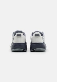 White and navy athletic shoes with a mesh upper, textured heel, and a cushioned sole. Features grey accents and a striped pull tab.