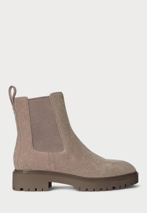 Bottines Chelsea en daim taupe avec panneaux élastiques sur les côtés et une languette de tirage, dotées d'une semelle en caoutchouc brun épaisse avec un motif pour une meilleure adhérence.