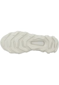 Sula av en sko som har ett vitt gummimaterial med ett robust, multidirektionellt mönster och formade konturer för grepp.
