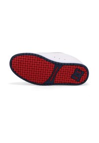 Vit sneakers med en strukturerad röd gummisula. Har blå detaljer med logotyp på sidan och perforerade ventilationshål på ovansidan.