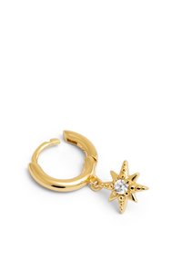 Pendiente de aro dorado con un charm de estrella de ocho puntas colgante que presenta una gema transparente central, sobre un fondo blanco.