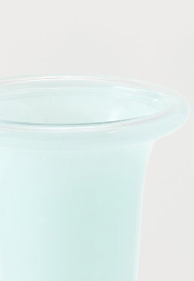 Διαφανές πλαστικό κύλινδρο ανοιχτού γαλάζιου χρώματος με φαρδύ χείλος, σε απλό λευκό φόντο.