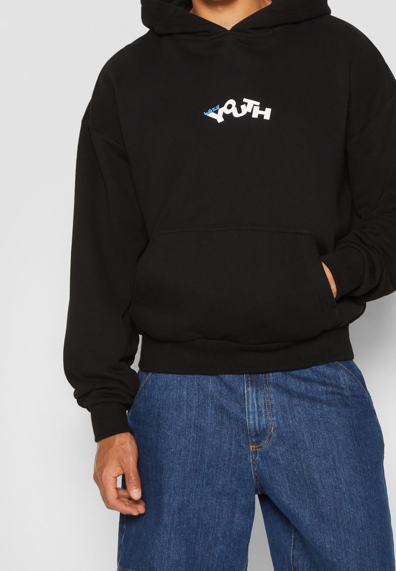 Felpa nera con cappuccio e tasca frontale, con un logo "YOUTH" in bianco e blu. Tessuto morbido, vestibilità ampia e polsini e orlo a coste.