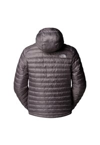 Grå puffjacka med huva, har kviltat mönster, mjuk textur, elastiska ärmar och en liten logotyp på övre ryggen.