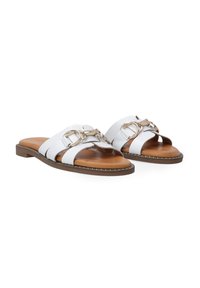 Weiße Rutschen-Sandalen mit goldenen Beschlägen, die zwei breite Riemen und eine braune Sohle aufweisen, akzentuiert durch ein dekoratives Steppdetail.