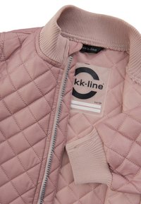 Pyntet, lyserød bomberjakke med ribbet krave og manchetter, fuld lynlås og et mærke på indersiden, der angiver størrelse 104.