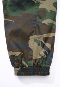 Pantalones jogger con patrón de camuflaje en tonos de verde, marrón y azul. Cintura elástica con textura recogida en el tobillo.