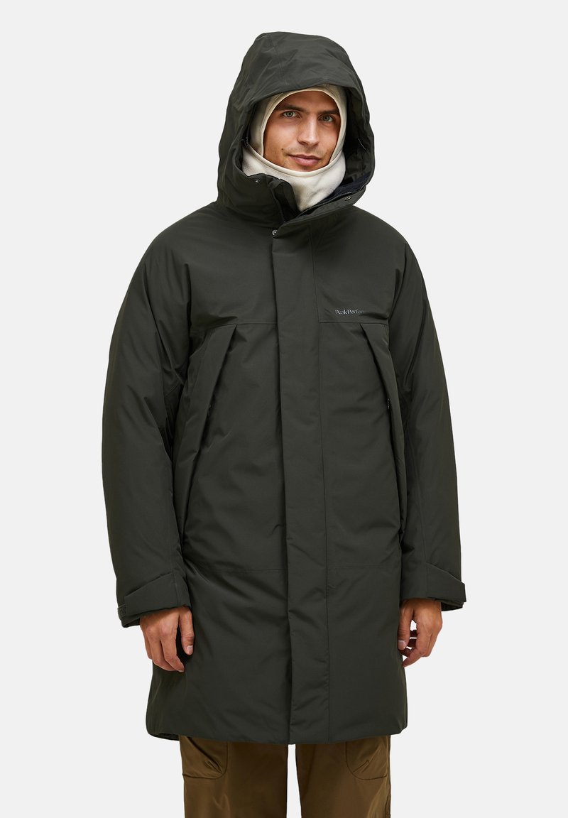 Mørkegrønne pufferjakke med hætte, der har en lynlåslukning og to frontlommer. Glat tekstur og oversized pasform for varme og dækning.
