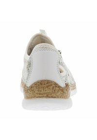 Chaussure blanche et texturée avec une semelle beige mouchetée, fermeture éclair à l'arrière et découpe sur le dessus.