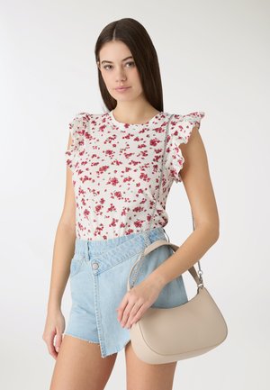 Top floreale bianco con maniche arricciate, abbinato a pantaloncini di jeans azzurri. Tiene una borsa a tracolla beige con forma curva e tracolla a catena.