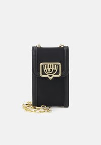 Černá kožená kabelka přes rameno se zlatým kováním ve tvaru oka, texturovaným povrchem a odnímatelným zlatým řetízkem.