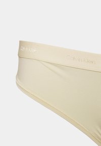 Cuecas beiges da Calvin Klein com tecido suave, faixa elástica com o nome da marca em letras em relevo e construção sem costuras.