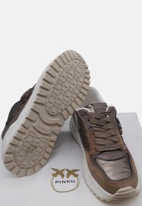 Sneaker marrone e metallico con una parte superiore in suede testurizzato, suola imbottita e battistrada in gomma con motivo. Logo del marchio visibile sul lato.