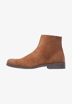 Braune Wildleder-Stiefelette mit einer glatten, matten Oberfläche. Verfügt über einen niedrigen Blockabsatz und ein gestepptes Design entlang der Kanten.