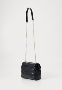 Black leather shoulder bag with a quilted chevron pattern, gold chain strap, and smooth finish. Compact rectangular shape.