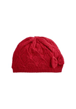 Beanie lavorato a maglia rosso con un motivo a diamante testurizzato, caratterizzato da un design a spirale sulla parte superiore e un'accents in forma di fiocco sul lato.