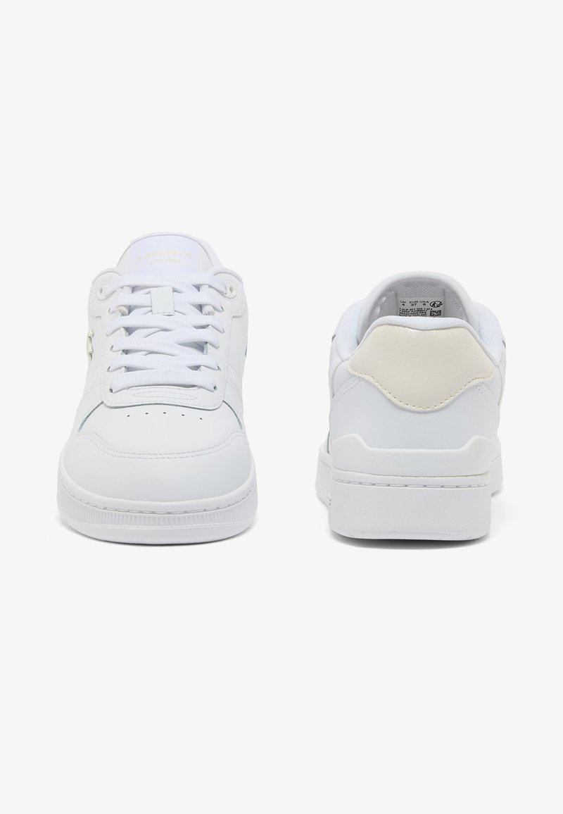 Pair of white low-top sneakers, one showing front with laces, the other showing back with beige heel tab, on plain white background.