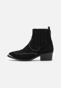 Botas de tobillo de ante negro con costuras decorativas y acentos de tachuelas. Punta afilada y un tacón bajo en bloque. Detalle de canalé vertical en la parte trasera.