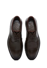 Zapatos de vestir de cuero marrón oscuro con una textura suave, con puntera redondeada, diseño de cordones y una marca minimalista en la plantilla.