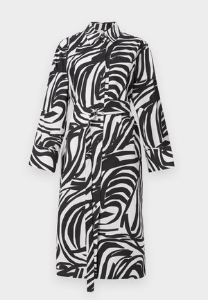 Black and white button-up shirt dress with long sleeves, featuring a bold leafy pattern, a tied waist belt, and a classic collar.