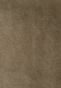 Tapis marron avec une surface douce et texturée. Les fibres sont denses, créant une sensation de confort. Couleur uniforme avec des variations subtiles.