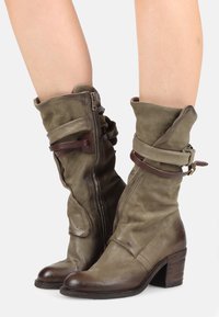 Oliivivihreät nahka nilkkasaappaat, joissa on löysä muotoilu, ruskeat soljet, sivuvetoketju ja pinoamaton puinen korko.