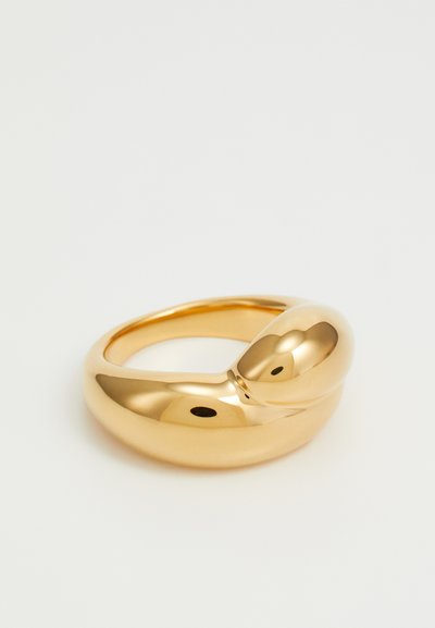 Gold-tone ring featuring a smooth, rounded design with a prominent, bulbous section and a seamless finish. Polished, reflective surface.