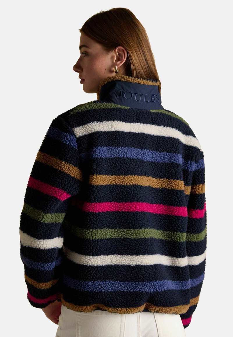 Fleece jacket with horizontal stripes in navy, pink, green, brown, and white. Features a high collar with embossed "Joules" logo.