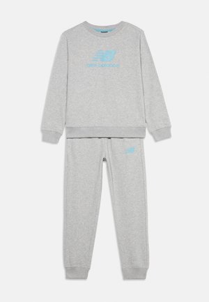Valgehalli New Balance pusa ja dressipükste komplekt helesiniste logodega rinnal ja vasakul reiel, valgel taustal.