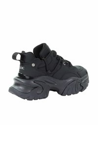 Czarny sneaker z wyściełanym wierzchem, teksturowaną podeszwą i wyraźnymi krzywiznami. Posiada sznurówki, pętelkę na pięcie i akcenty z logo.