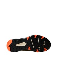 Suela negra con un patrón de tracción único, con acentos en naranja y gris. Diseñada para ofrecer agarre, con un corte central para mayor flexibilidad.