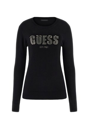 Maglione nero con scollatura a girocollo, maniche lunghe e polsini a coste. Presenta il logo "GUESS" in borchie argentate e "EST.1981" sotto di esso.