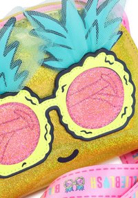 Trblietavé zlaté vrecko s dizajnom ružových slnečných okuliarov, žltým rámom, akcentami z tyrkysového tylu a ružovým popruhom s vzorom okuliarov.