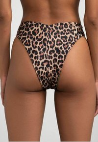 Costume da bagno leopardato a vita alta con una superficie liscia e elastica, design a vita bassa sul retro e copertura minima.