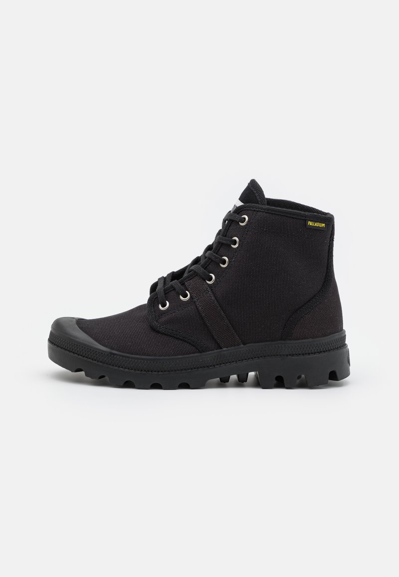Botas de tobillo negras hechas de tejido texturizado, con ojales y cordones de metal, una puntera de goma y suela gruesa con relieve.
