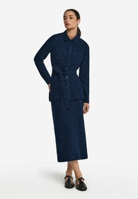 Lång marinblå stickad klänning med en matchande jacka med bälte, med två bröstfickor, knäppning framtill och rak passform.